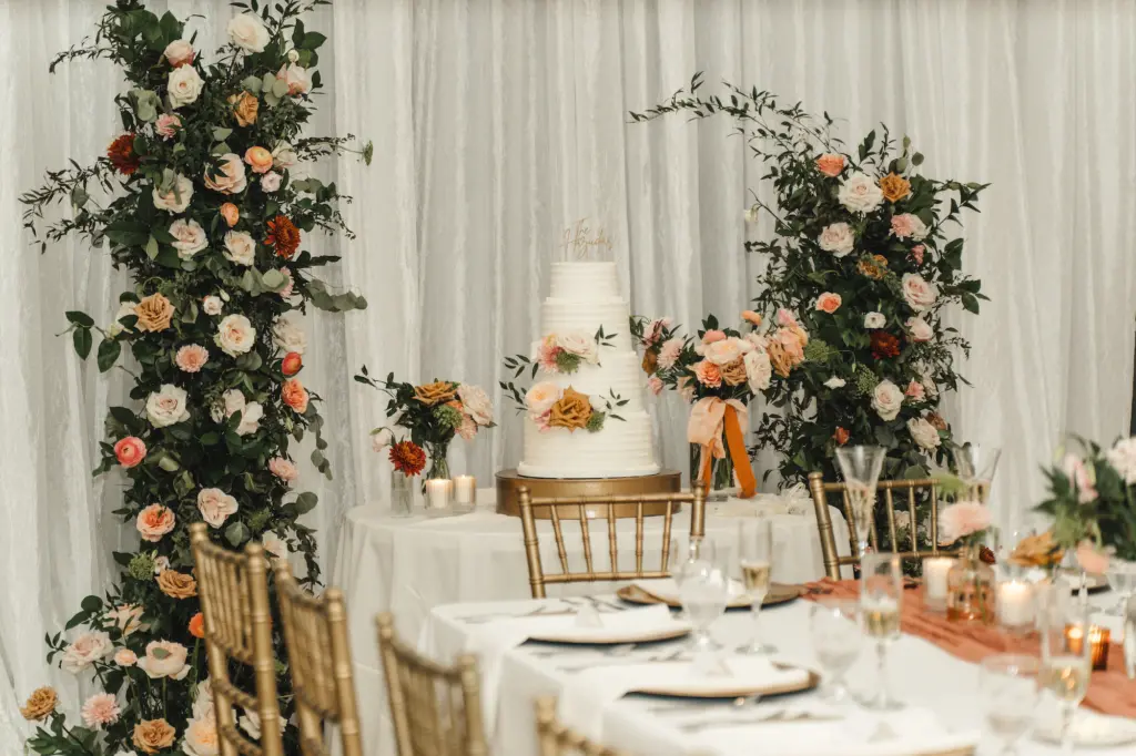 Wedding Reception Cake Table Inspiration with King Protea, White, Pink, and Orange Roses, Greenery Asymmetrical Flower Stand