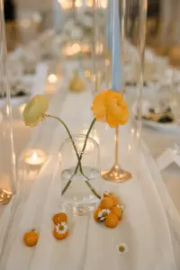 Summer Yellow and Orange Roses In Bud Vase Wedding Reception Centerpiece Inspiration with Fruit and Blue Taper Candles