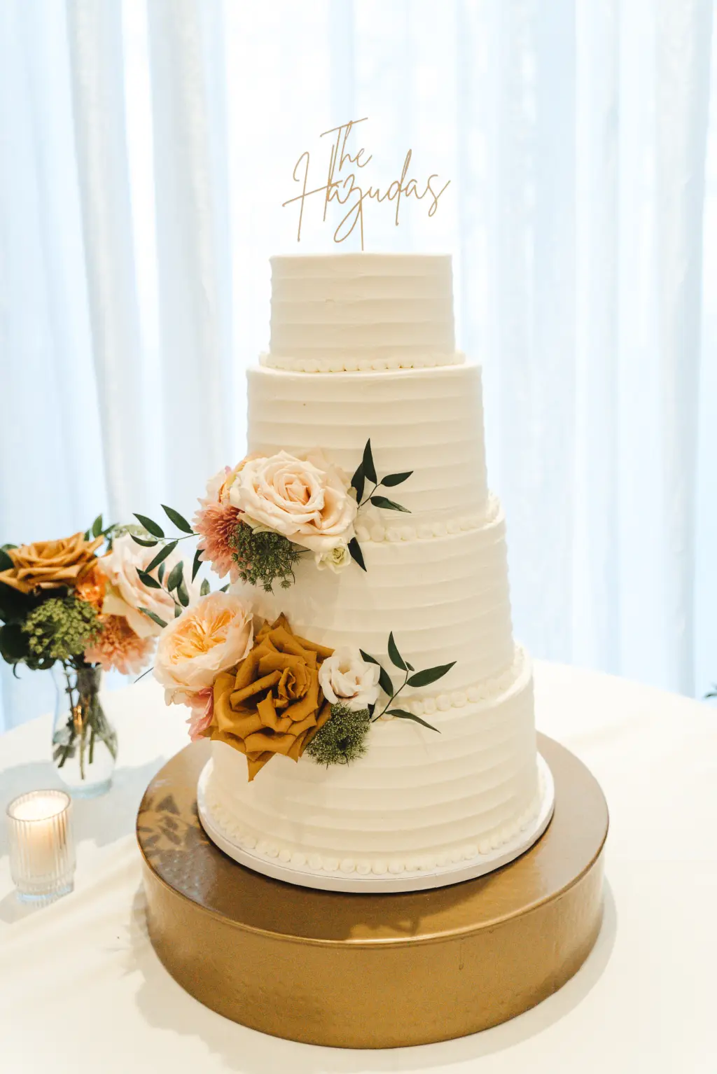 Four-Tiered White Buttercream Wedding Cake with Custom Gold Cake Topper and Rose Accents