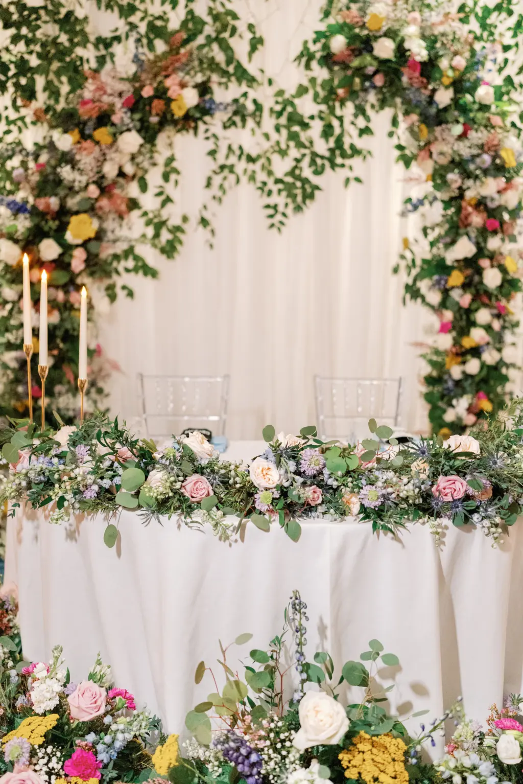 Whimsical Sweetheart Table with Colorful Backdrop | Pink Roses, Baby's Breath, and Greenery Table Garland Ideas | Clearwater Florist Lemon Drops Weddings and Events