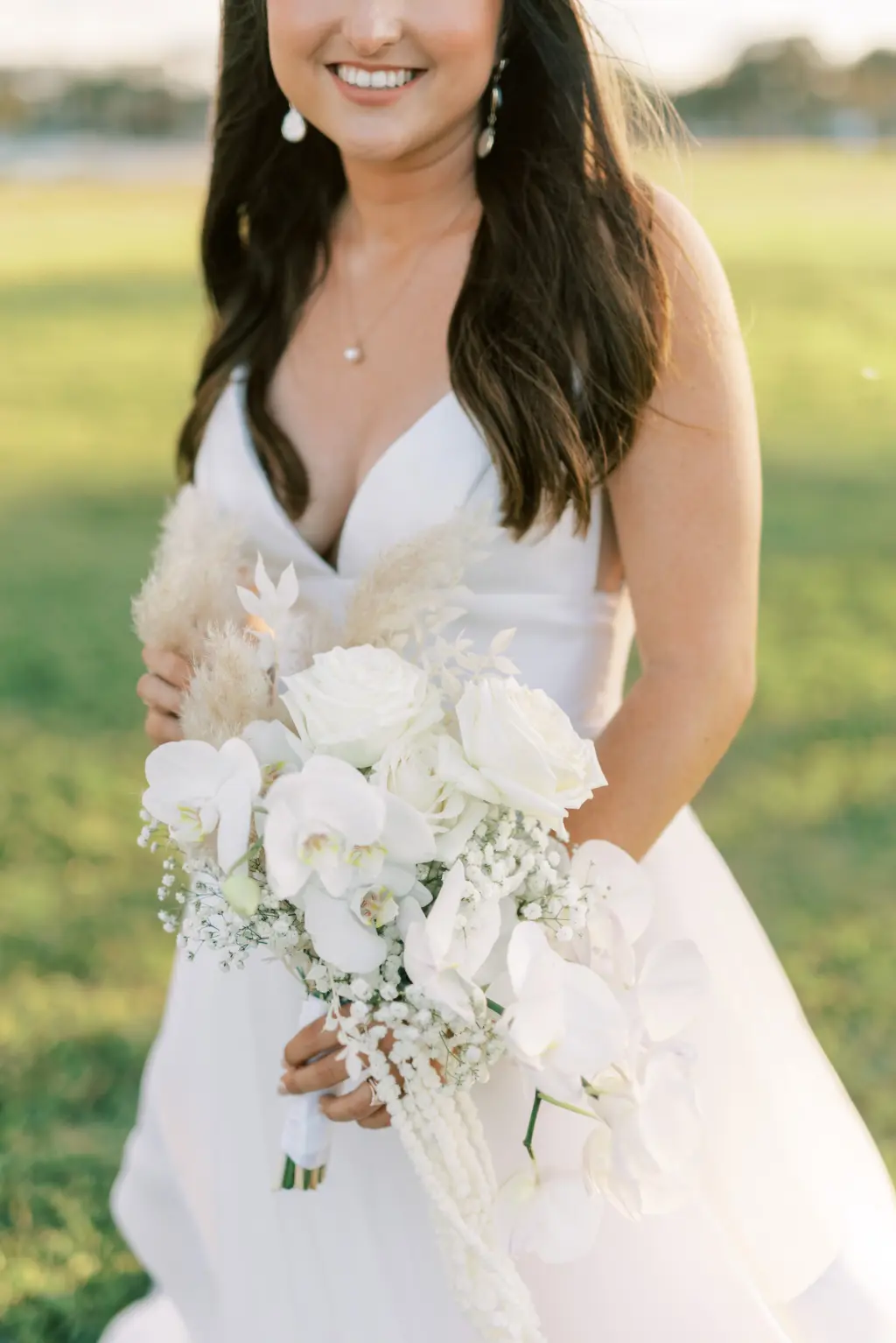 Monochromatic White Wedding Bouquet with Cascading Wisteria, Orchids, Roses, Baby's Breath, and Boho Pampas Grass Inspiration