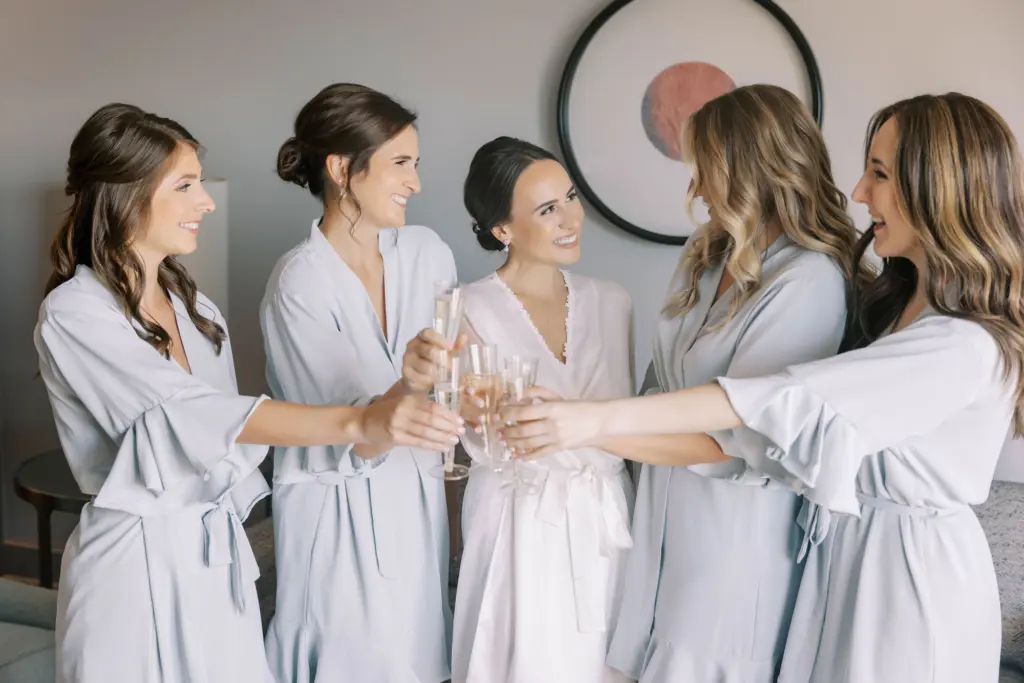 Bride and Bridesmaids Toasting Champagne in Matching Dusty Blue Robes
