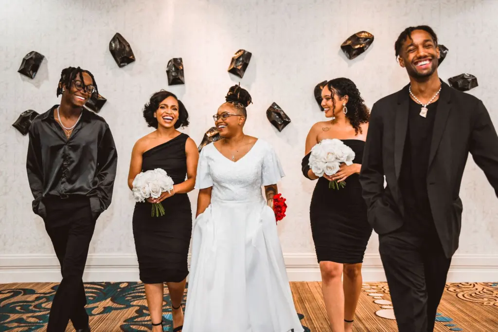 Bride with Bridesmaids and Bridesmen in all Black Mix and Match Wedding Portrait | White Rose Bouquet Ideas