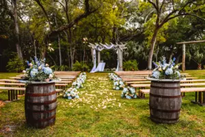 Rustic Outdoor English Garden Bridgerton Wedding Ceremony Inspiration | Blue Hydrangeas and Stock Flowers, White Roses and Wine Barrel Aisle Decor Ideas | Bench Seating, Pergola Arch | Tampa Bay Event Venue Tabellas at Delaney Creek | Tampa Event Planner B Eventful