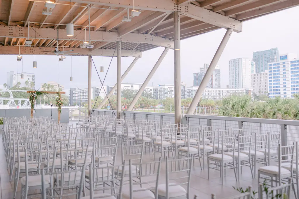 Elegant Downtown Tampa Outdoor Rooftop Wedding Ceremony Decor Inspiration | Silver Chiavari Chairs | Rustic Wooden Arch Ideas | Venue Tampa River Center