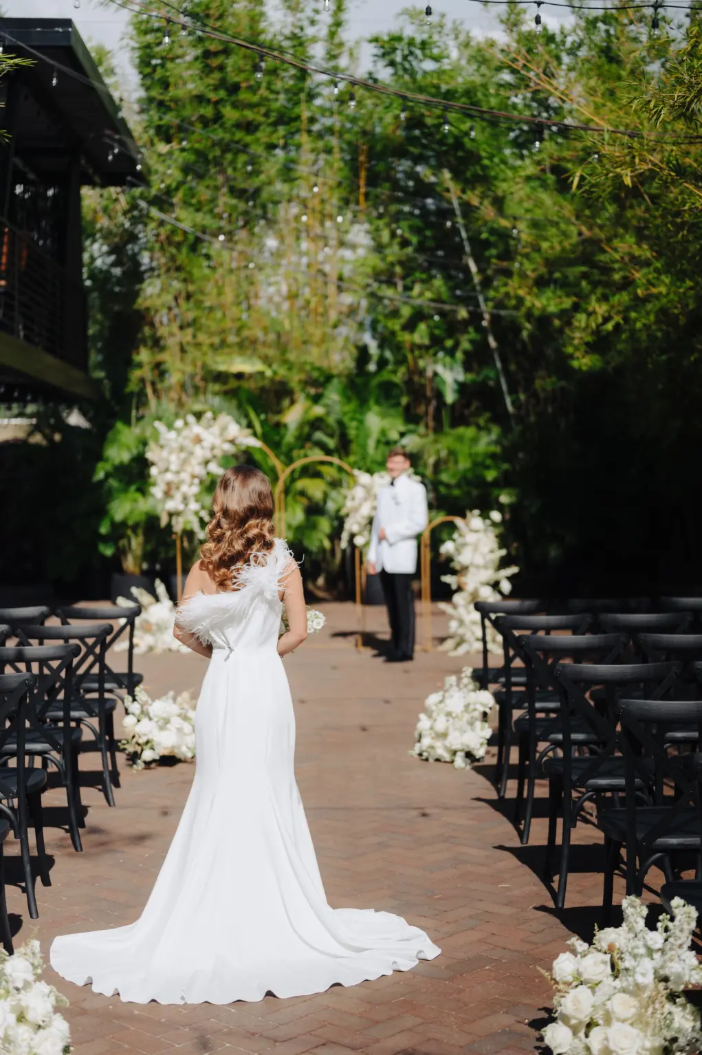 Modern Outdoor Courtyard Wedding Ideas with Black Chairs and White Ceremony Aisle Flowers | Downtown St Pete NOVA 535 Wedding Venue | Florist Marigold Flower Co | Photographer Mcneile Photography | Videographer Sabrina Autumn Photography | Planner Kelci Leigh Events