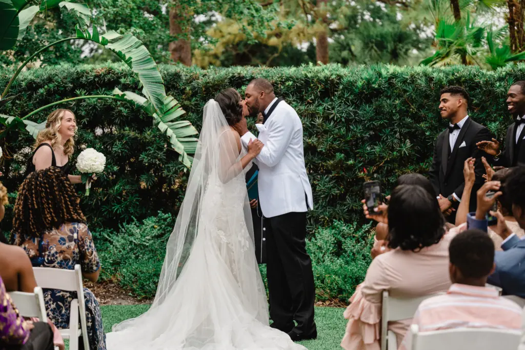 Bride and Groom First Kiss at Elegant Black Tie Wedding Garden Ceremony | Event Venue Tampa Garden Club