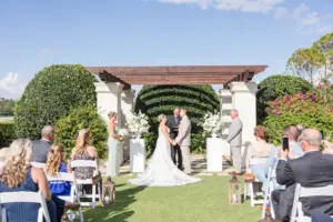 Bride and Groom Vow Exchange Wedding Portrait | Outdoor Wedding Ceremony with Wood Pergola | Tampa Bay Event Venue The Concession Golf Club