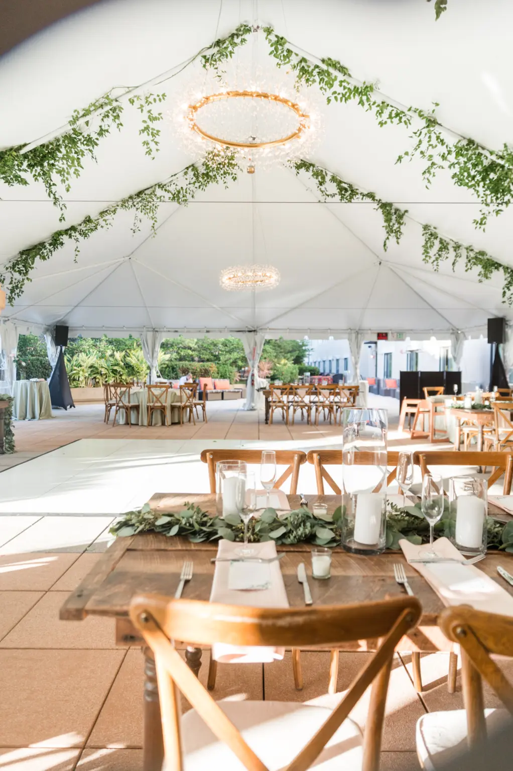 White Tented Boho Wedding Reception with Hanging Eucalyptus | White Dance Floor | Farmhouse Tables and Wooden Crossback Chairs | Tampa Bay Kate Ryan Event Rentals | Venue The Epicurean
