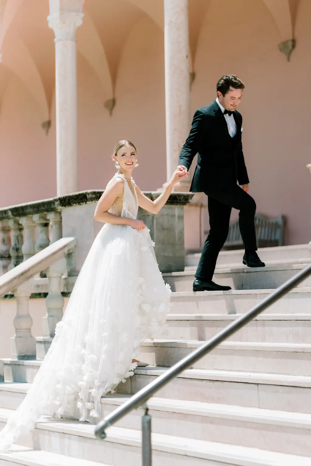 Bride and Groom Walking up Stairs Wedding Portrait | Sarasota Photographer Amber Yonker Photography | Venue The Ringling Museum | White Tulle Deep V Neckline, A-Line Marchesa Italian Wedding Dress with Floral Applique Inspiration