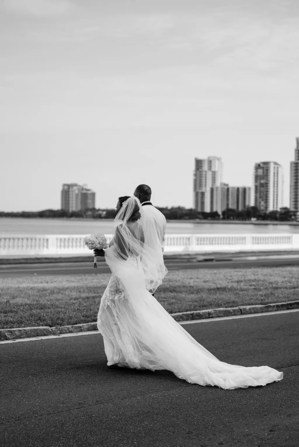Bride and Groom Walking Down Bayshore Wedding Portrait | Tampa Bay Photographer Iyrus Weddings | Black and White Wedding Photography Portrait