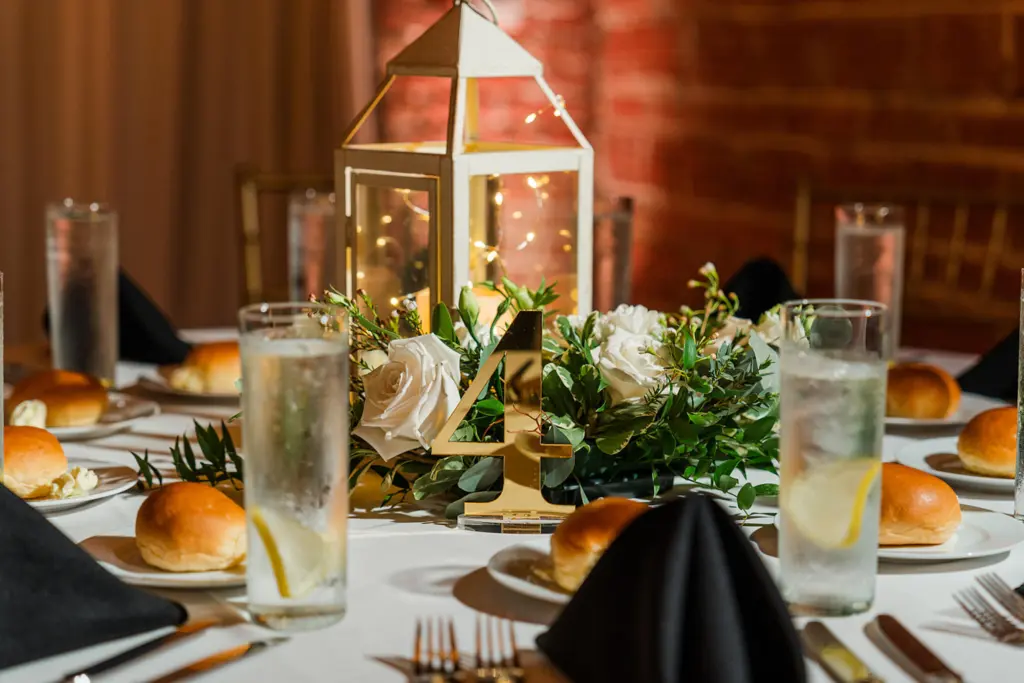 Acrylic Gold Table Number Ideas | Lanterns with White Roses and Greenery Wedding Reception Centerpiece Decor Inspiration | Tampa Bay Caterer Olympia Catering