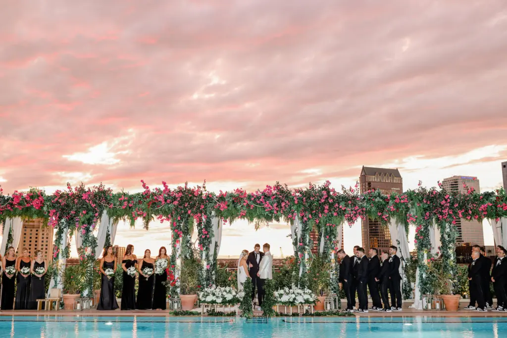Sunset Rooftop Poolside Wedding Ceremony Inspiration | Extravagant Tall Bougainvillea and Fern Backdrop with White Hydrangeas, Roses, Anemone, and Greenery Decor Floor Arrangements | Tampa Bay Planner Breezin Weddings | Photographer Lifelong Photography | Downtown Event Venue The Edition Hotel Tampa Water Street Rooftop at Sunset