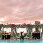 Sunset Rooftop Poolside Wedding Ceremony Inspiration | Extravagant Tall Bougainvillea and Fern Backdrop with White Hydrangeas, Roses, Anemone, and Greenery Decor Floor Arrangements | Tampa Bay Planner Breezin Weddings | Photographer Lifelong Photography | Downtown Event Venue The Edition Hotel Tampa Water Street Rooftop at Sunset