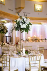Elegant White and Gold Winter Wedding Reception Inspiration | Gold Chiavari Chairs | Tall Flower Stand with White Roses, Baby's Breath, Hydrangeas, Pampas Grass, and Greenery Centerpiece Decor Ideas