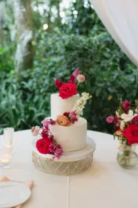 Round Two-Tiered White Buttercream Wedding Cake Inspiration with Pink Roses, Orange Ranunculus, Bougainvillea, and White Stock Flower Accents
