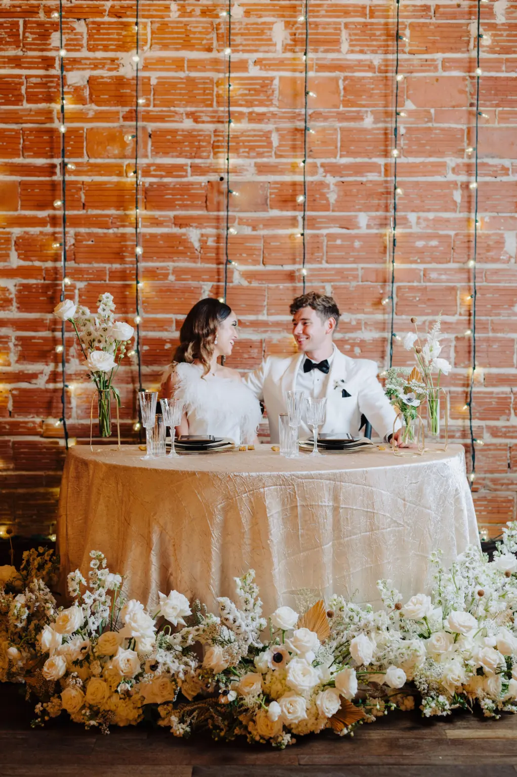 Modern Great Gatsby Themed Wedding Reception Inspiration | Sweetheart Table with Gold Textured Tablecloth | White Stock Flowers, Roses, Anemones, Baby's Breath, and Dried Palm Leaves | Tampa Bay Kate Ryan Rentals | St Petersburg Florist Marigold Flower Co | Planner Kelci Leigh Events | Venue NOVA 535
