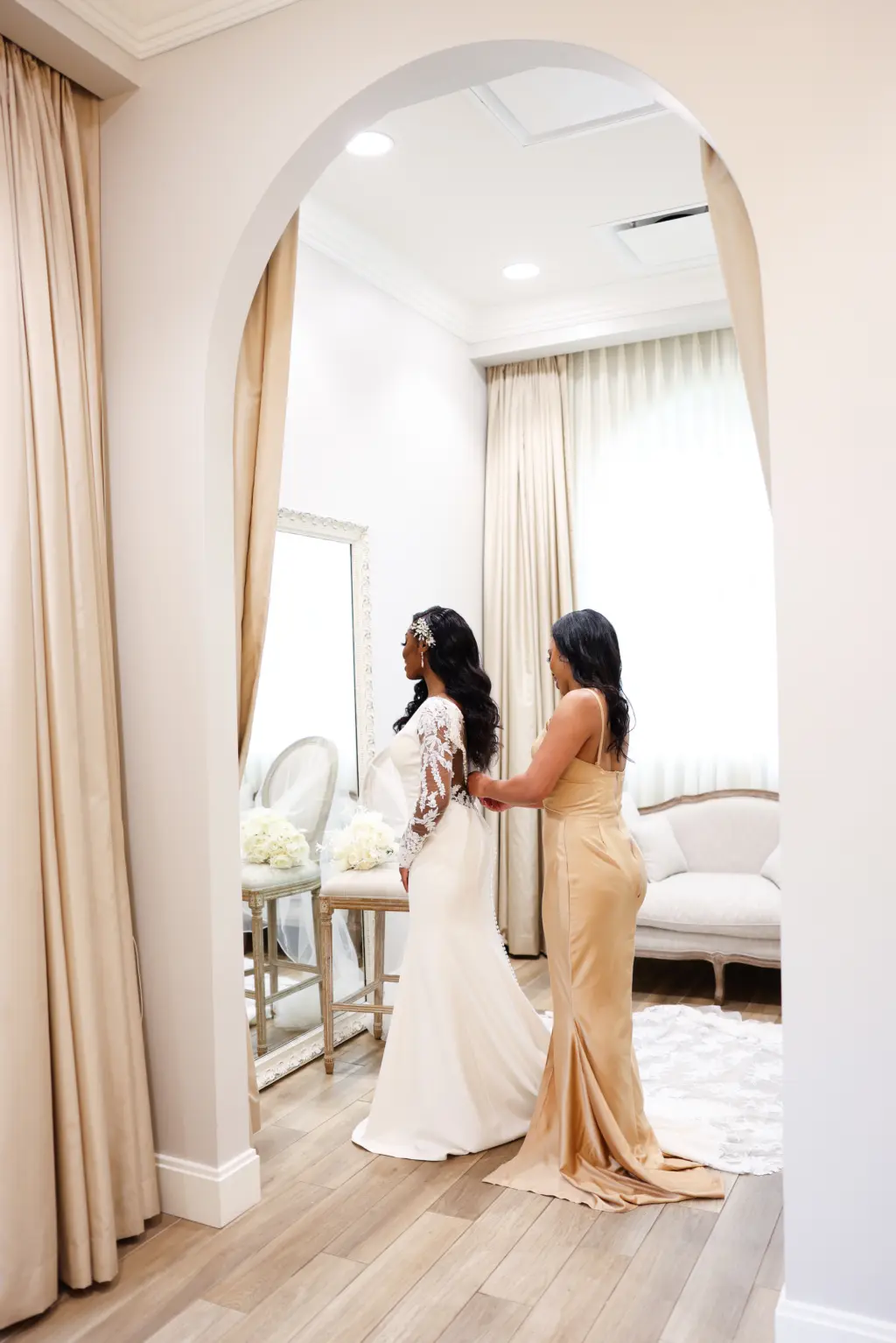 Bride and Bridesmaid Getting Ready | Sheer Lace Long Sleeve Fit and Flare Wedding Dress Ideas | Satin Champagne Bridesmaid Dress Inspiration | Safety Harbor Venue Harborside Chapel