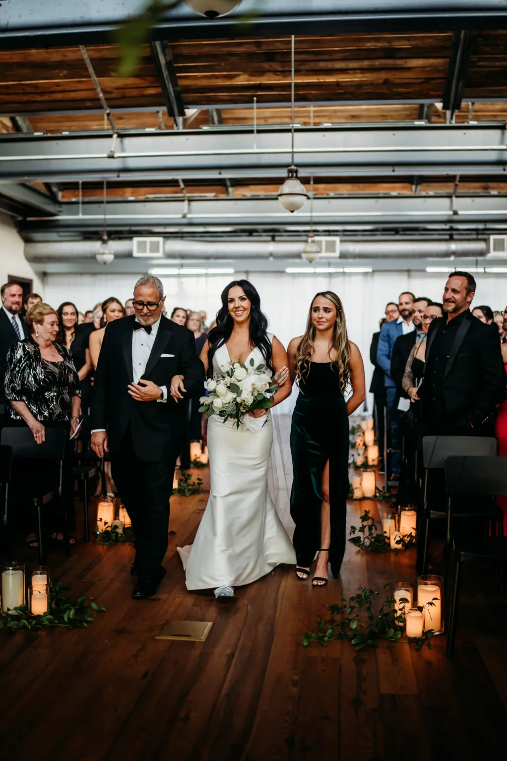 Bride, Father, and Sister Walking Down Aisle | Industrial Indoor Black and White Wedding Ceremony Decor Inspiration