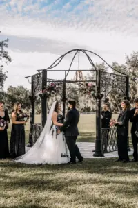 Bride and Groom Gothic Halloween Wedding Ceremony Vow Exchange Inspiration | Black Metal Gazebo and Chandelier