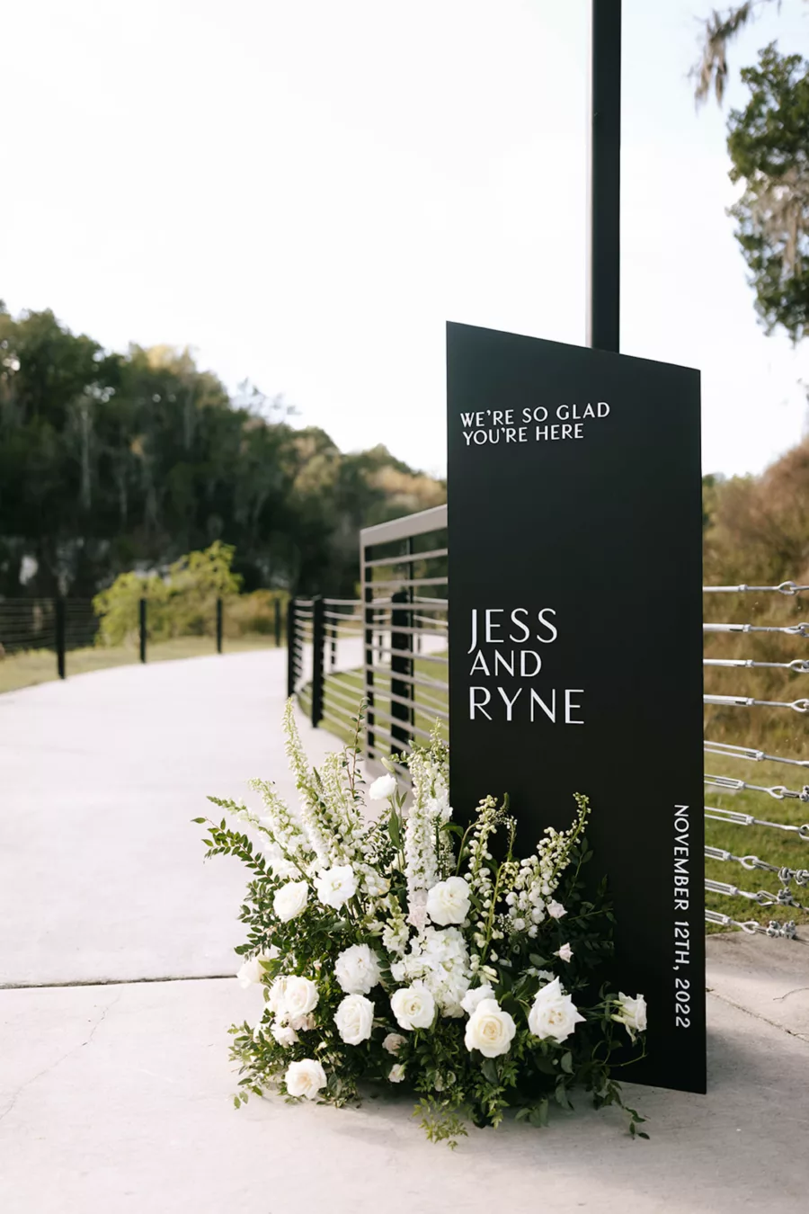 Modern Black and White Welcome Wedding Ceremony Sign Ideas | White Snapdragons, Roses, and Greenery Floral Arrangement Decor Inspiration