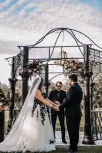 Gothic Halloween Wedding Ceremony with Black Metal Gazebo and Chandelier Inspiration | Strapless Black Lace, White Tulle, A-Line David's Bridal Wedding Dress Ideas
