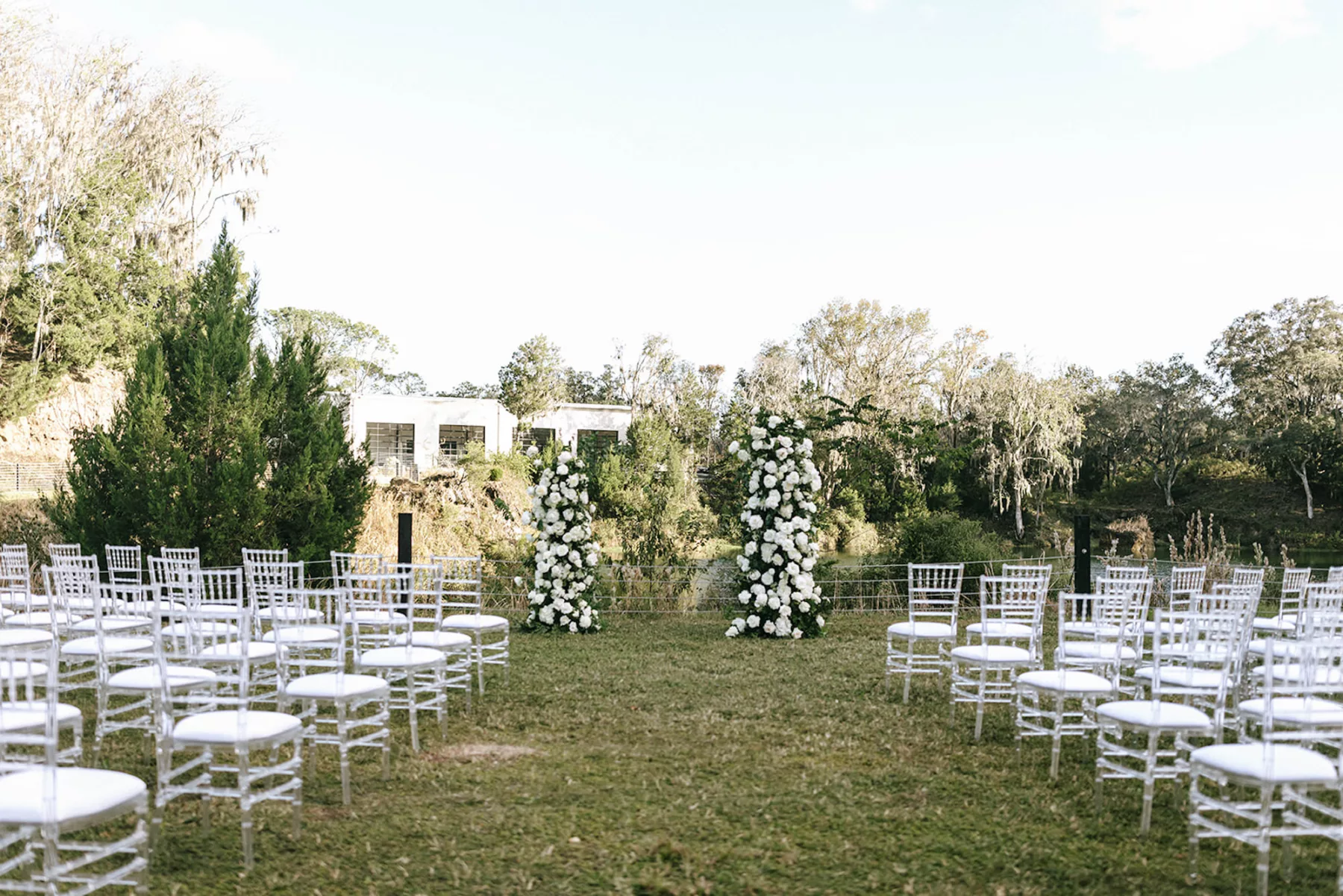 Asymmetrical Floral Arbor with White Roses and Greenery Inspiration | Chiavari Ghost Chairs for Modern Outdoor Wedding Ceremony | Tampa Bay Florist Bloom Shakalaka