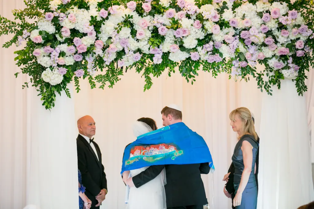 Jewish Wedding Ceremony Tallit Ideas | Whimsical Chuppah with Pink and Purple Roses, White Hydrangeas, and Greenery