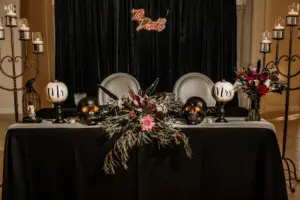 Spooky Halloween Inspired Black Wedding Reception Sweetheart Table Ideas | 'Til Death Neon Sign | Skulls and Pumpkin Centerpiece Decor Inspiration | Tampa Bay Planner B Eventful