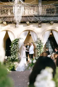 Glamorous White and Gold Outdoor Wedding Ceremony with Drapery Decor Inspiration | White Roses and Greenery Arch Flower | Arrangements | Crystal Chandelier | Sarasota Shannon Kelly Films