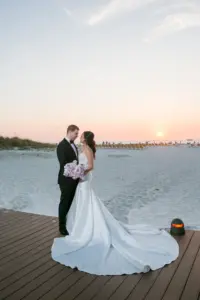 Bride and Groom Sunset Clearwater Beach Wedding Portrait | White Removable Spaghetti Strap Lace and Satin Mermaid Wedding Dress Inspiration | Tampa Bay Boutique Truly Forever Bridal | Tampa Bay Event Venue Sandpearl Resort Hotel | Photographer Carrie Wildes Photography