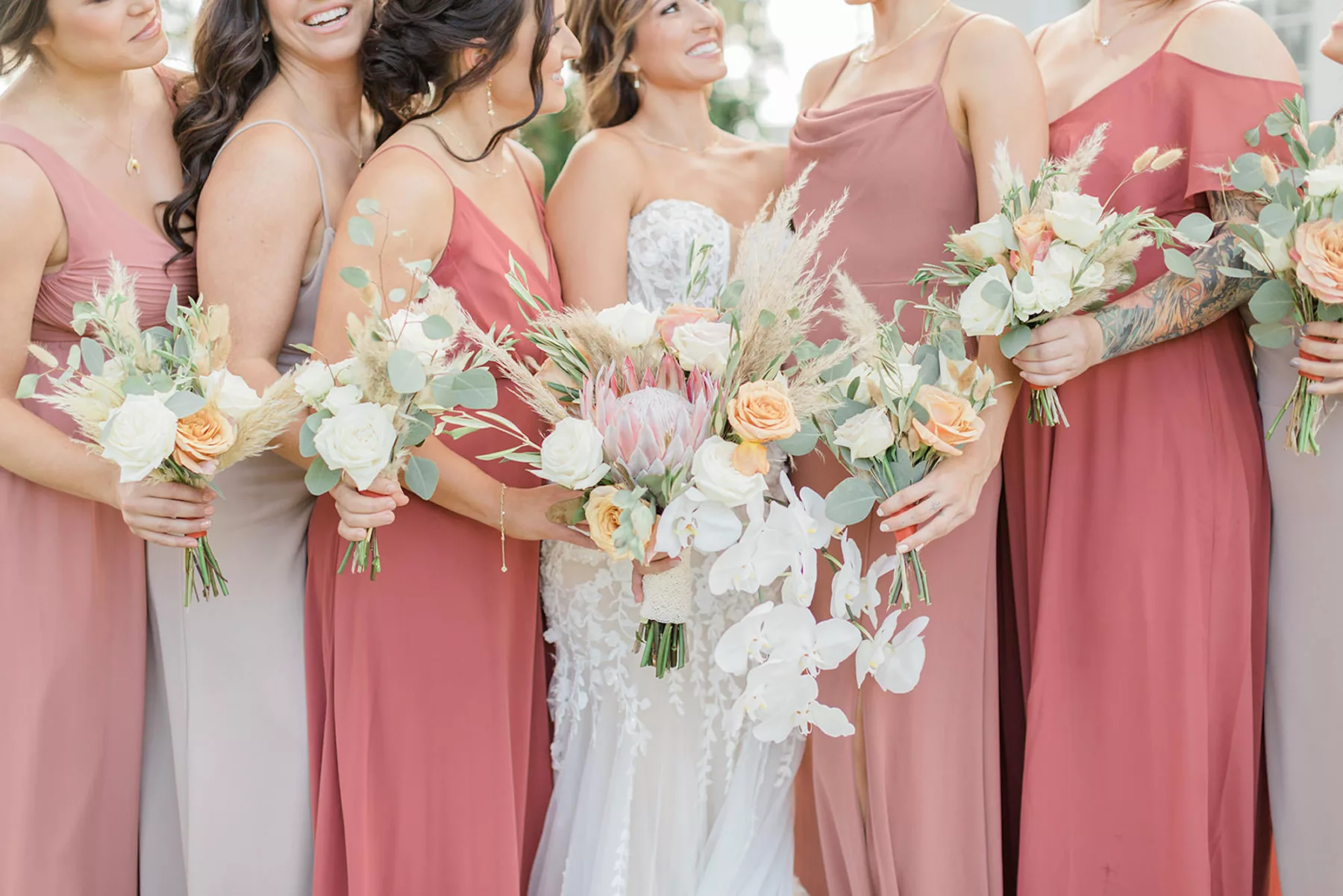 Mismatched Chiffon Floor Length Taupe, Dusty Rose, Terracotta Bridesmaid Dress Ideas | Boho Wedding Bouquets with Pampas Grass, White and Orange Roses, Pink King Protea, Orchids, and Eucalyptus Inspiration