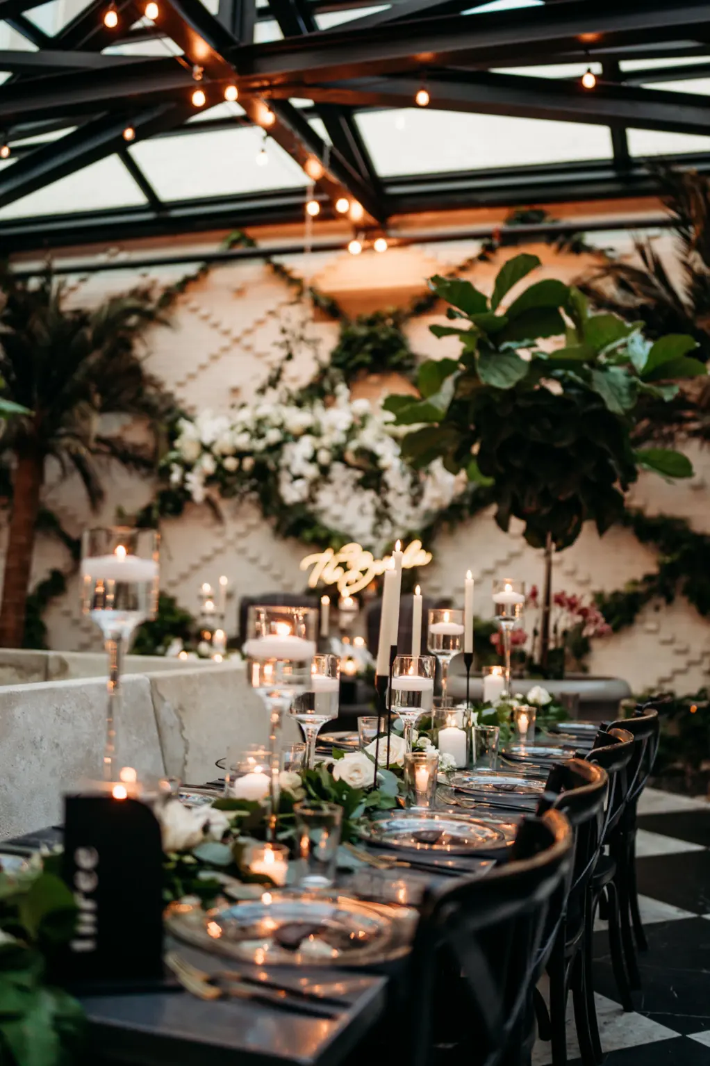 Modern Romantic Black and White Conservatory Wedding Reception Inspiration | Floating Candles, White Roses, and Greenery Garland Centerpiece Decor Ideas | Tampa Bay Planner Wilder Mind Events | Downtown Event Venue Oxford Exchange