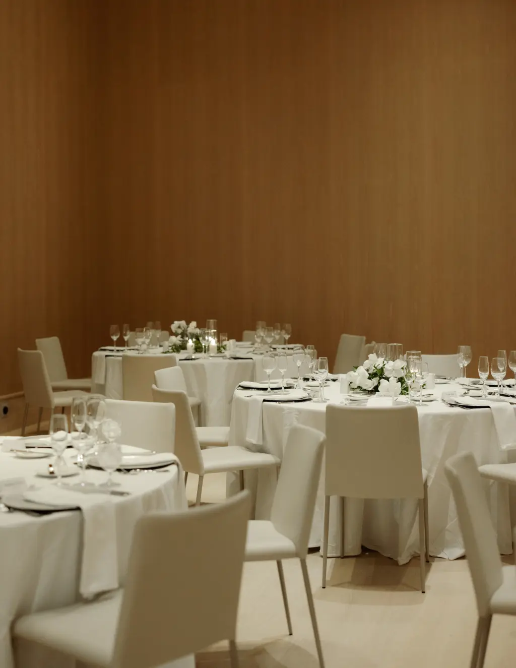 Modern Minimalist White Wedding Reception Decor Ideas | White Table Linens with Cream Hotel Banquet Chairs and Low White Centerpieces