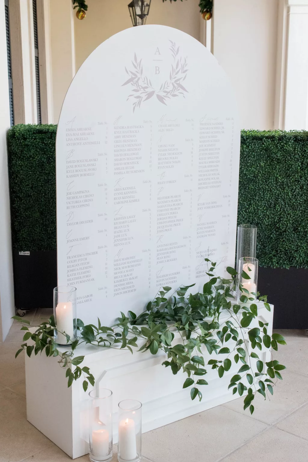 Elegant White Arch Wedding Reception Seating Chart with Greenery and Pillar Candles Inspiration