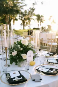 Glamorous Gold, White, and Black Outdoor Italian Wedding Reception Table Setting Decor Ideas | Gold Beaded Chargers, Black Napkin Linen, White Rose, Lemon, Greenery and Taper Candle Centerpiece Inspiration | Tampa Bay Videographer Shannon Kelly Films