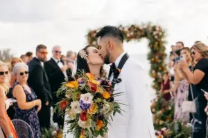 Bride and Groom Just Married | Moody Fall Halloween Inspired Black Tie Beach Wedding Ceremony Ideas | Jewel Tone Bridal Bouquet Inspiration
