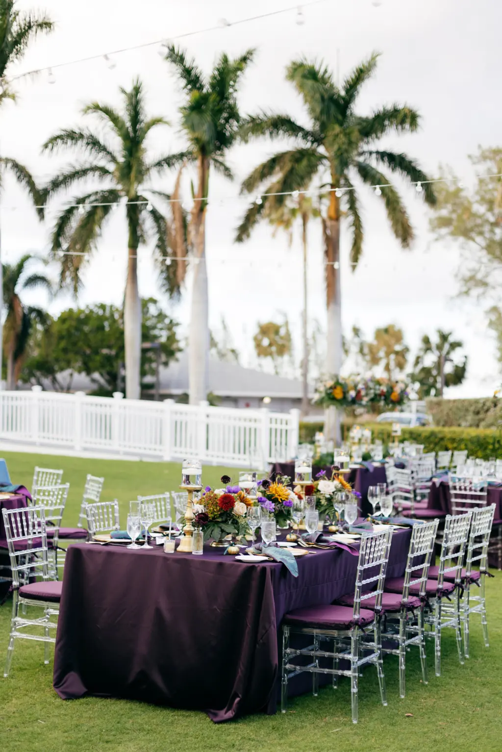 Jewel-Toned Moody Fall Wedding Reception Table Decor Ideas | Ghost Chiavari Chairs with Eggplant Dark Purple Feasting Table Linen Inspiration | Sarasota Event Venue The Resort at Longboat Key Club