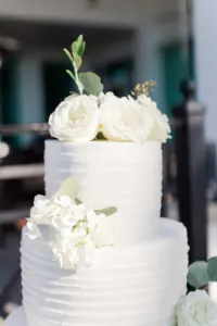 Round Two-Tiered Textured White Buttercream Wedding Cake with White Rose Topper and Hydrangea Accent