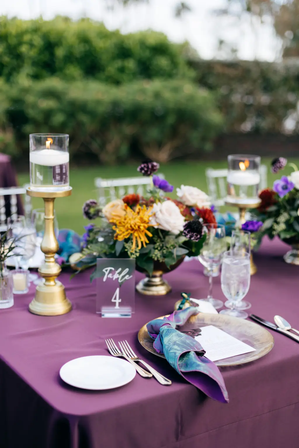 Jewel-Toned Moody Fall Wedding Reception Table Decor Ideas with Gold Floating Candles and Gold Charger Plates