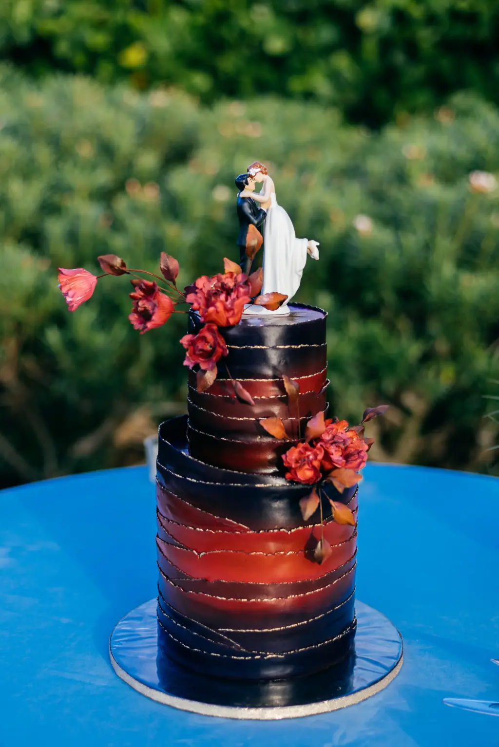 Round Two-Tiered Black and Orange Halloween Fondant Wedding Cake with Bride and Groom Cake Topper and Fall Flower Accents