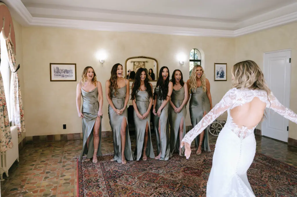 Bride and Bridesmaids First Look Wedding Portrait | Sheer White Long-Sleeve Lace Open Back Keyhole Mermaid Martina Liana Giselle Wedding Dress Inspiration | Satin Mismatched Sage Olive Green Bridesmaids Dress Ideas
