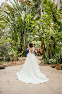 Bride and Groom Garden First Look Wedding Portrait | White Deep-V Neckline Open Back A-Line Lace Wedding Dress Inspiration | St. Petersburg Event Outdoor Venue Sunken Gardens
