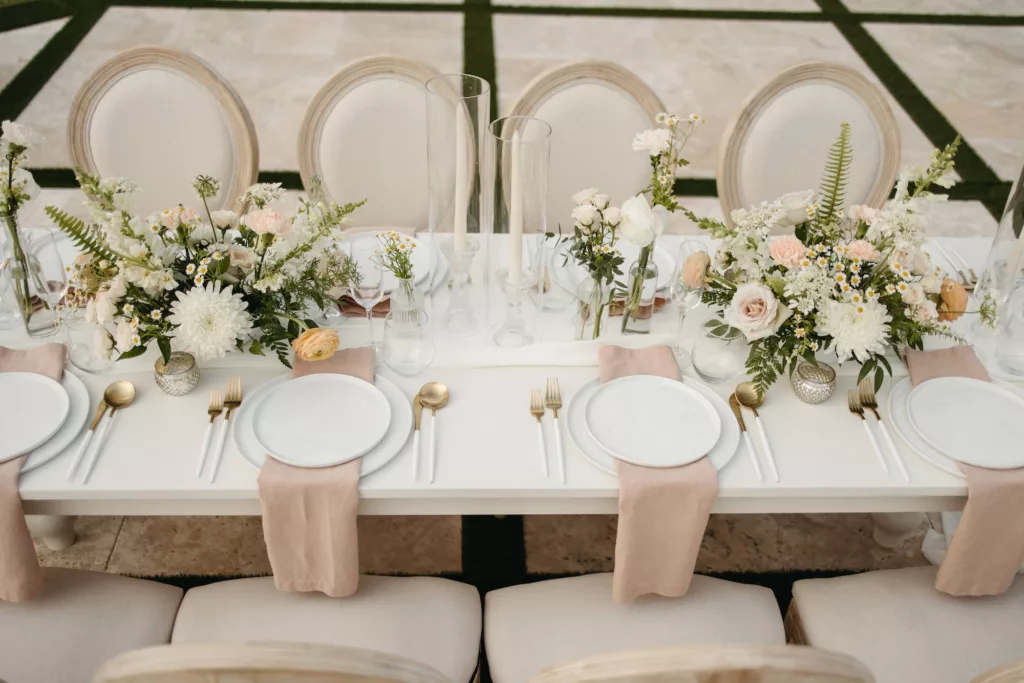 Neutral Spring European Inspired Wedding Reception Tablescape Ideas | Long Feasting Table | Gold and White Flatware Inspiration | Blush Linen Napkins | Taper Candles, White Roses and Feverfew Daisy Centerpiece Decor | Tampa Bay Event Planner The Olive Tree Weddings