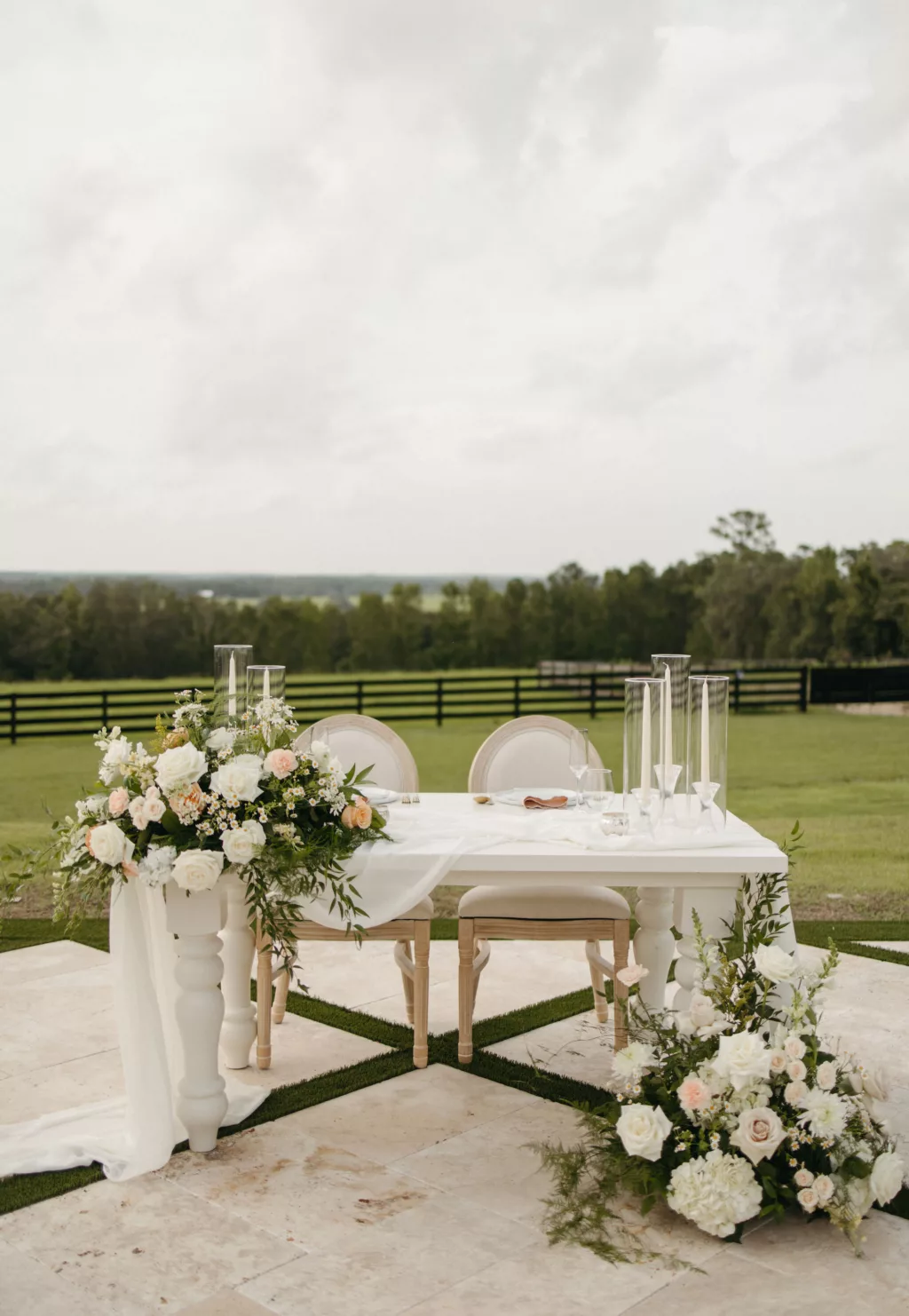 Elegant White Wedding Reception Sweetheart Table Inspiration | Taper Candle and Hurricane Glass Tube | Spring Table Top and Floor Floral Arrangement with Pink Roses, White Hydrangeas, and Greenery Ideas | Tampa Bay Event Venue La Hacienda on Snow Hill