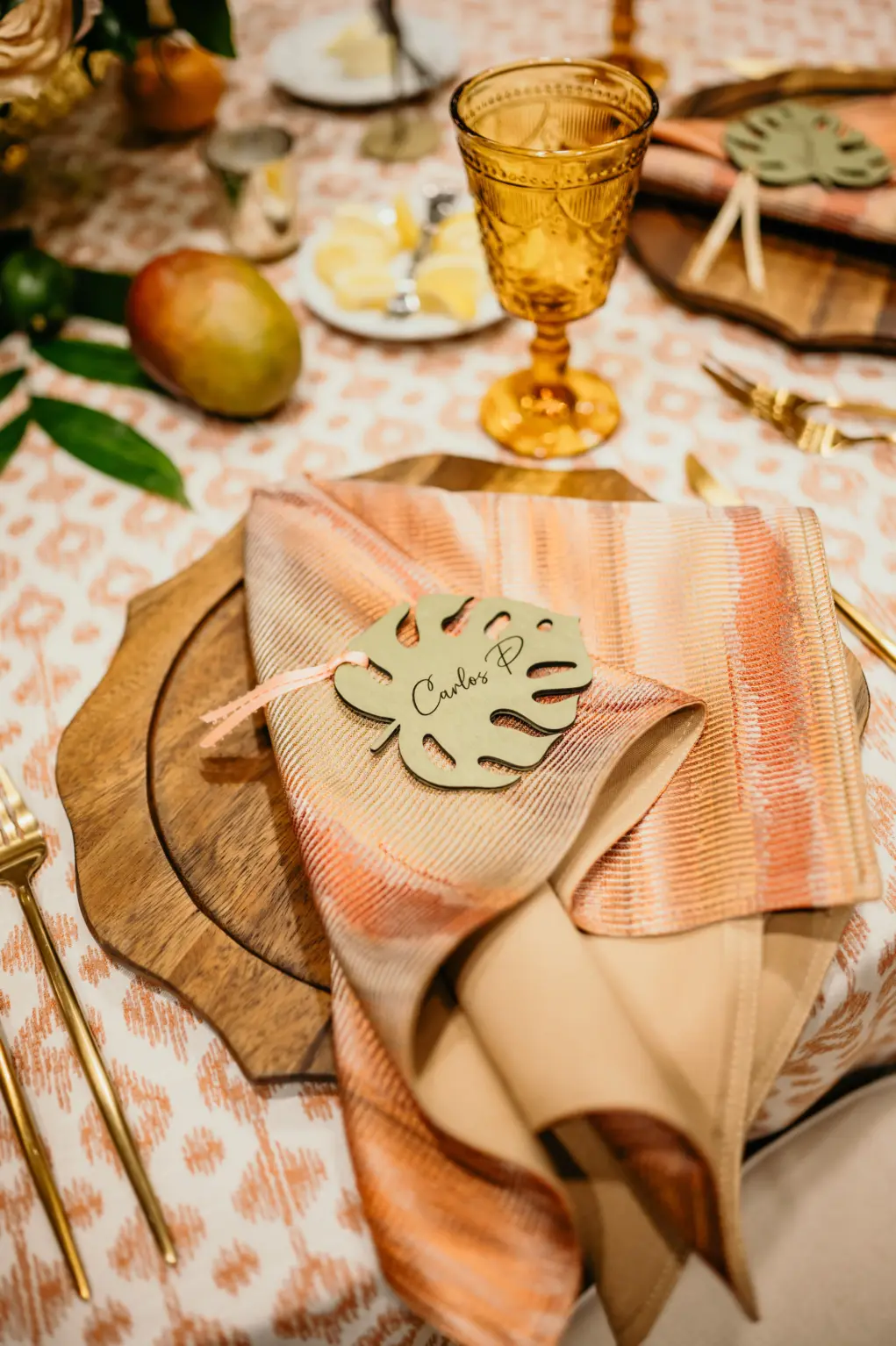 Laser-cut Monstera Leaf Place Card Inspiration | Tropical Wedding Reception Decor Ideas | Wood Charger Plate, Gold Flatware and Amber Vintage Glassware from Kate Ryan Event Rentals