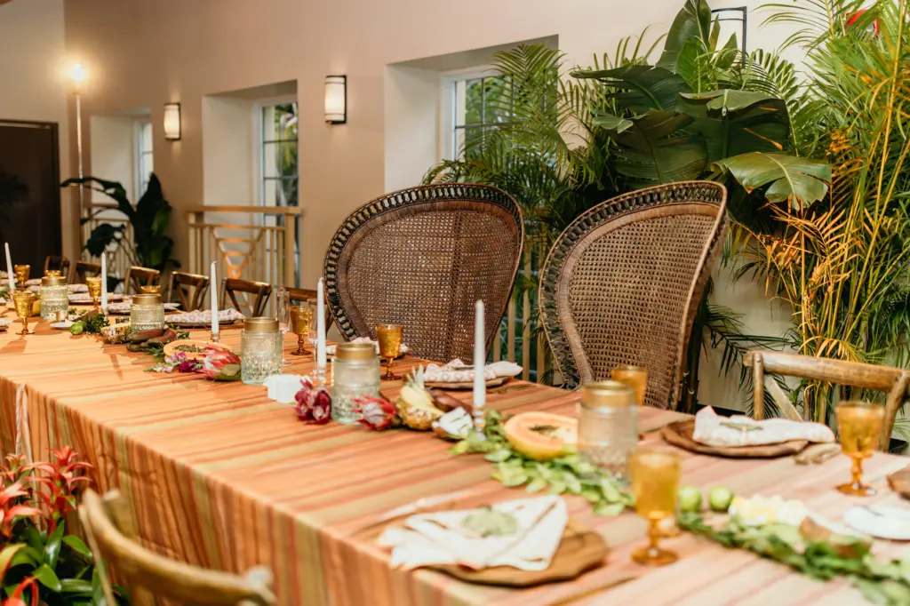 Tropical Wedding Reception Long Feasting Table Inspiration | Retro Rattan Peacock Chair Ideas | Taper Candle and Greenery Garland Centerpiece Decor | Tampa Bay Kate Ryan Event Rentals | Event Planner Eventfull Weddings
