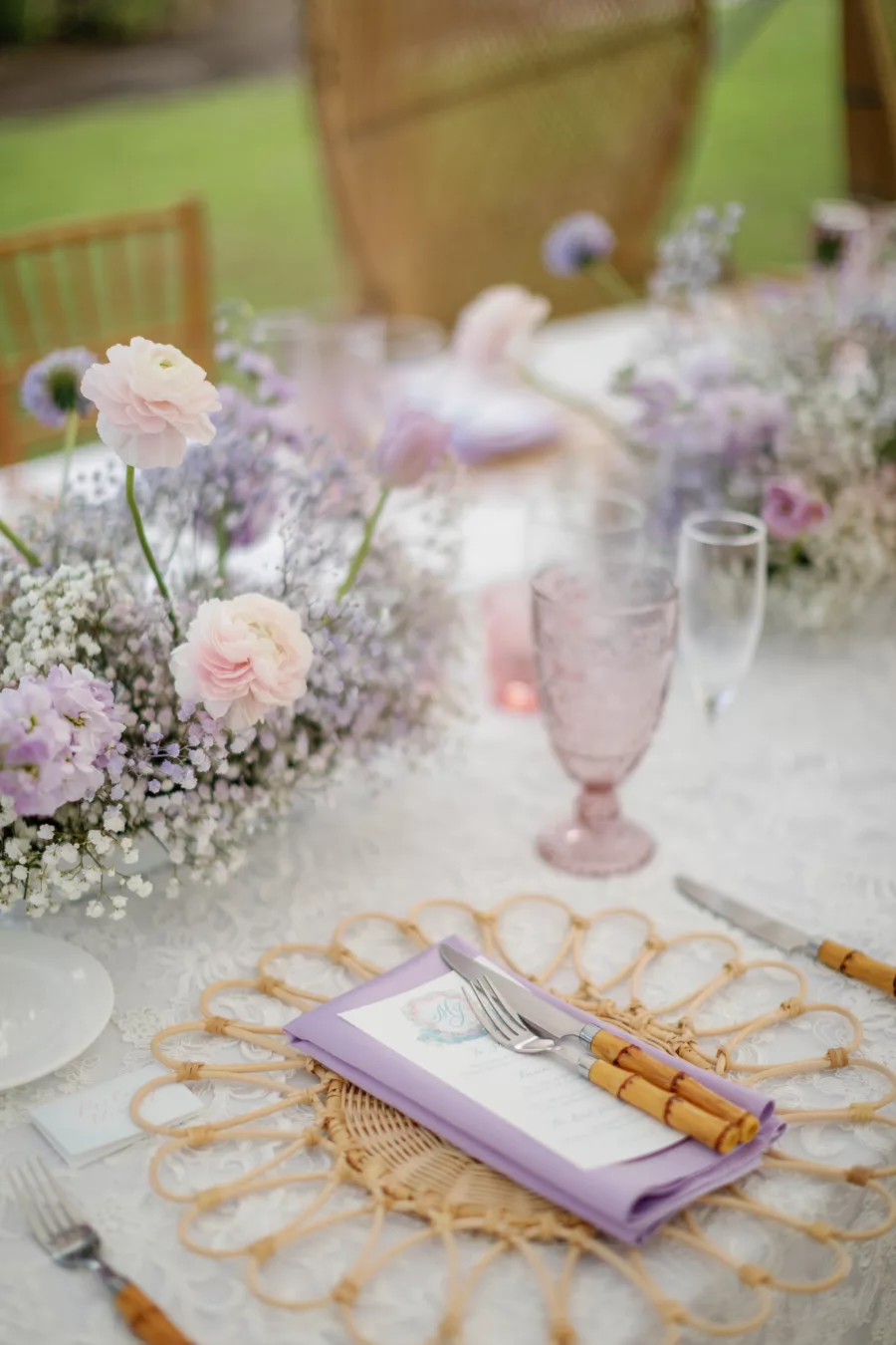Rattan Flower Placemat with Purple Linen, Bamboo Flatware | Purple Hydrangrea, Baby's Breath, and Pink Ranunculus Centerpiece Ideas | Luxurious Pastel Wedding Reception Inspiration