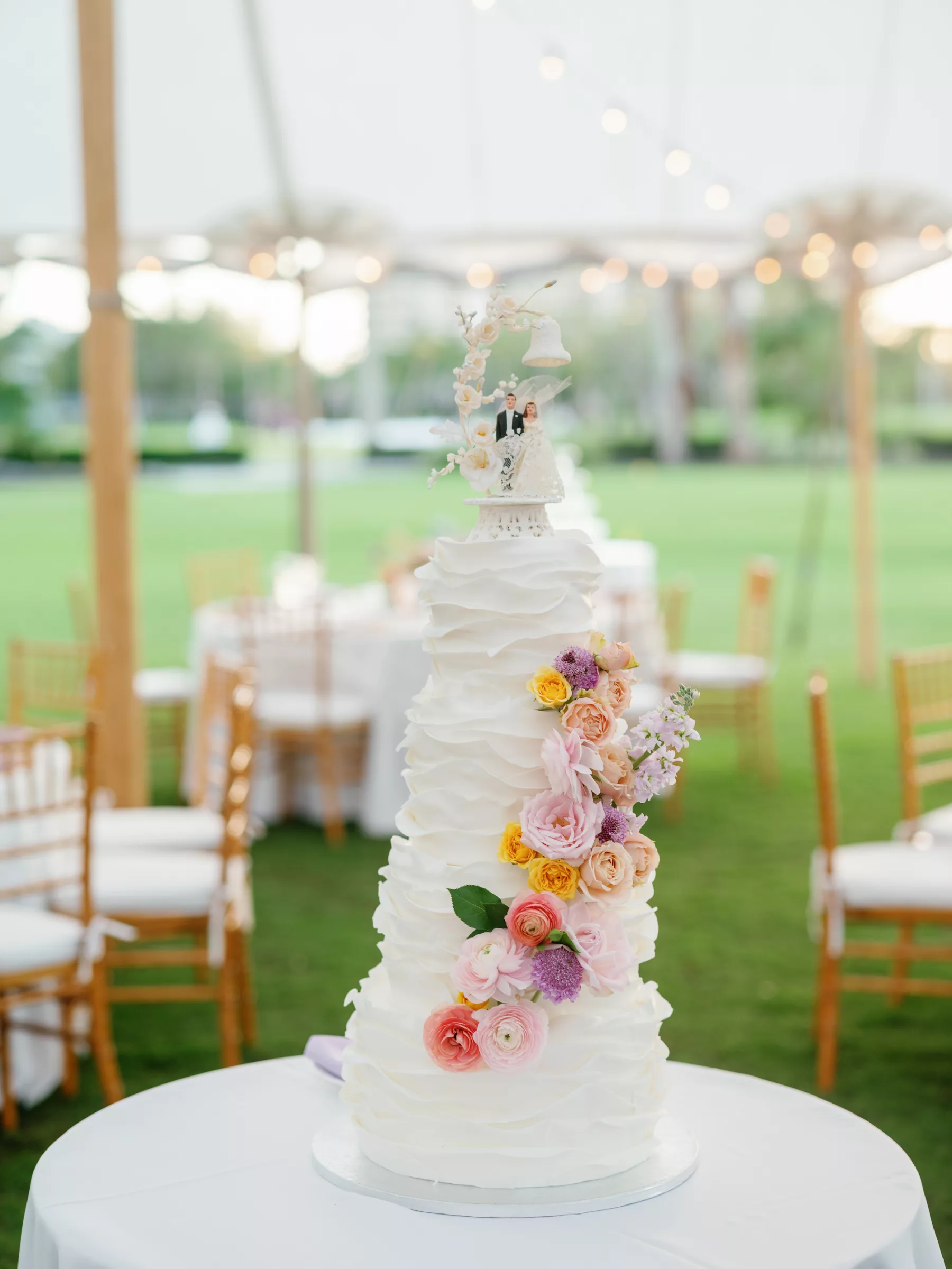 Whimsical Round White Textured Four-Tiered Wedding Cake with Pastel Rose Accents