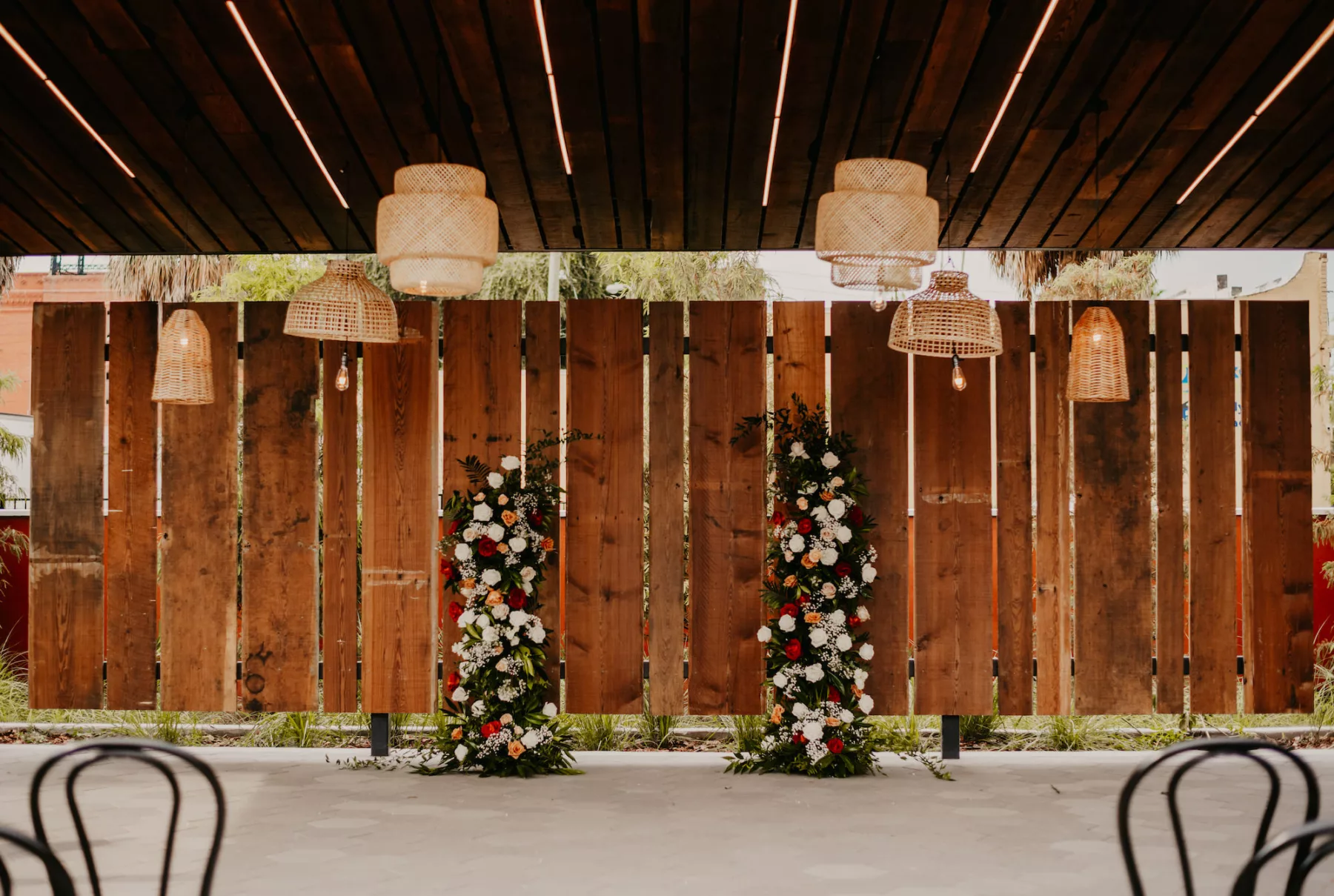 Outdoor Industrial Wedding Ceremony Inspiration | Rattan Light Fixture Ideas | Terracotta, Orange, and White Roses, Baby's Breath, and Greenery Backdrop | Tampa Courtyard Venue J.C. Newman Cigar Co.
